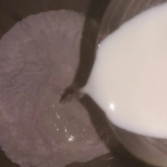 Tuang susu cair sambil uleni adonan