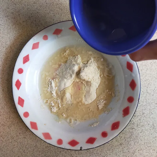 Membuat Bahan Basah : siapkan wadah, masukkan tepung terigu, garam, merica bubuk, kaldu jamur dan bawang putih bubuk, lalu tambahkan air es secukupnya.