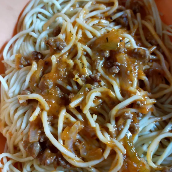 Campur saus daging bolognaise dengan spageti.