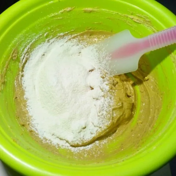 Campur terigu, baking powder, dan vanili bubuk. Masukkan ke dalam kocokan butter, gula, telur sambil diayak sedikit. Aduk rata.