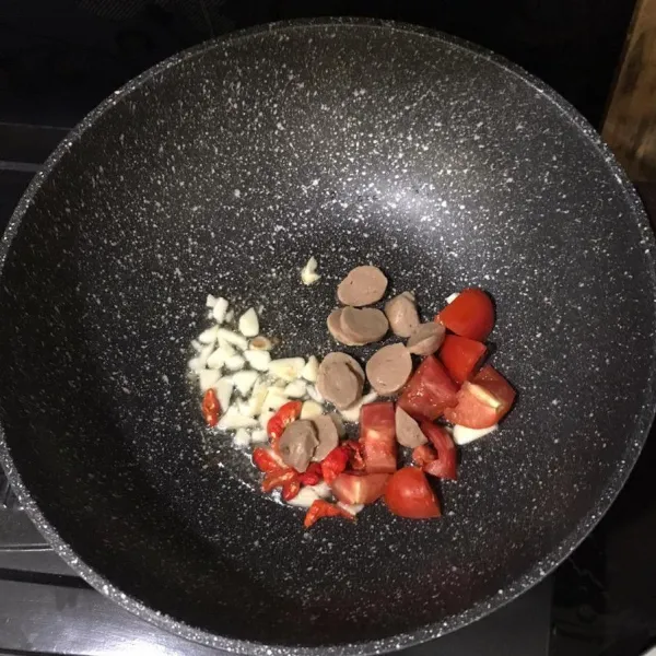 Masukkan tomat, cabe dan baso, masak setengah matang.