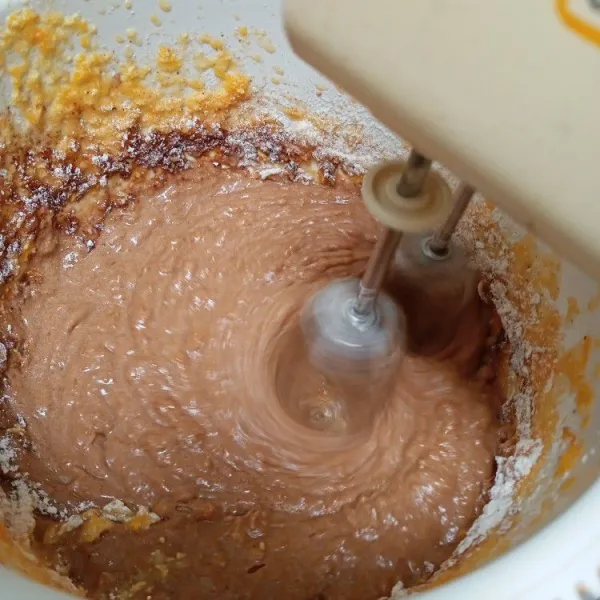 Kemudian masukkan tepung terigu, baking powder dan coklat bubuk. Mixer dengan kecepatan rendah.