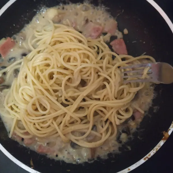 Lalu masukkan bahan saus dan spaghetti, aduk rata. Tata di piring lalu taburi oregano di atasnya