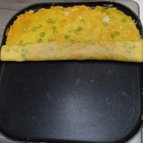 Membuat telur gulung : olesi wajan anti lengket dengan sedikit margarin. Tuang adonan telur merata. Masak dengan api kecil. Setelah telur 1/2 matang gulung dengan bantuan spatula.