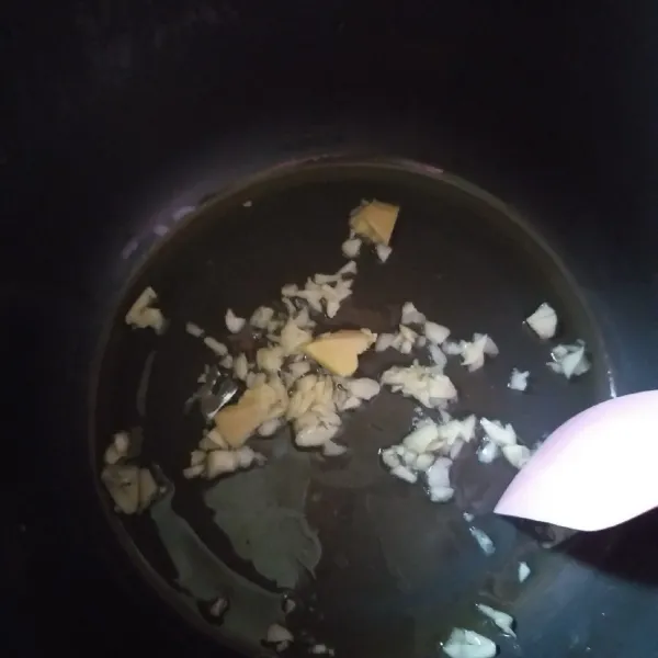 masak nasi: pertama cincang bawang putih dan iris jahe, masukan 1 sdm minyak goreng ke wajan magic com dan tumis bumbu hingga wangi.