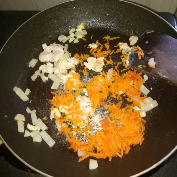 Siapkan pan dan panaskan minyak wijen. Tumis bawang bombay dan bawang putih sampai harum, masukan ayam aduk sampai berubah warna. Kemudian masukan wortel, aduk rata.