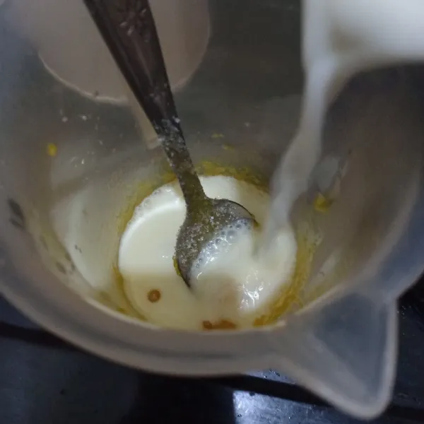 Campurkan kuning telur,gula pasir dan sedikit susu, aduk rata.