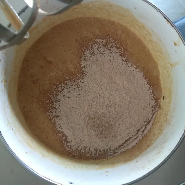 Masukkan tepung terigu, kayu manis, pala, cengkeh, dan jahe bubuk. Mixer hingga tercampur rata