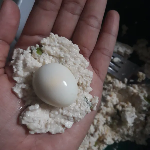 Ambil 1 sdm tahu, lalu pipihkan masukkan telur puyuh dan bulat-bulatkan.