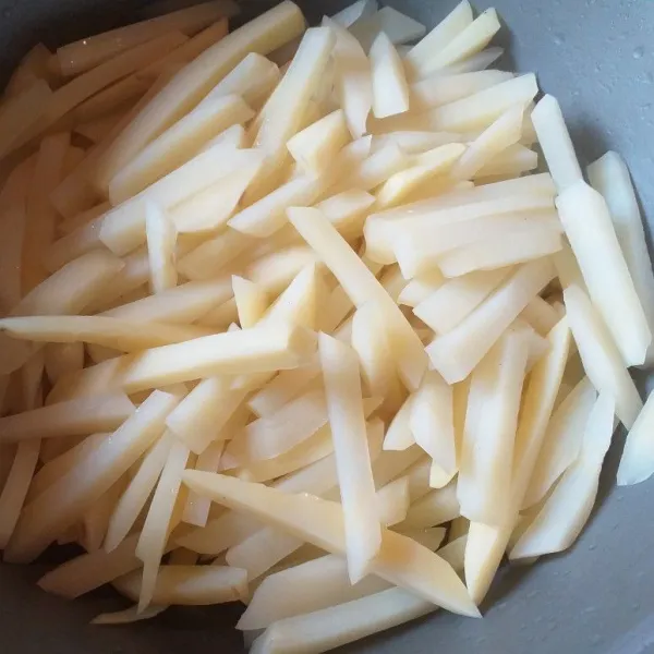 Simpan kentang di kulkas sampai dingin, kira-kira 10-15 menit. Setelah dingin, taburi kentang dengan tepung sampai merata. Agar lebih merata, masukkan kentang di toples, lalu masukkan tepungnya dan kocok sampai seluruh permukaan kentang berbalut tepung.