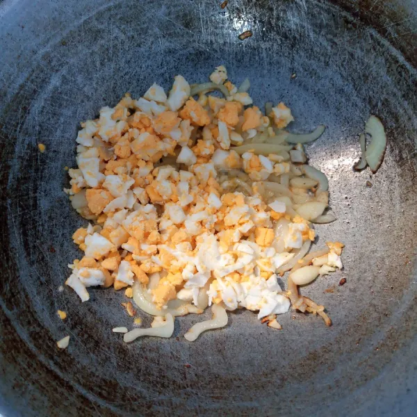 Tumis bawang putih dan bawang bombai sampai harum dan layu. Kemudian masukkan telur asin. Aduk rata.
