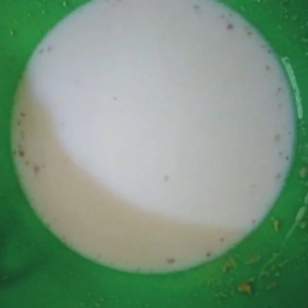 Tuang susu hangat dalam wadah, lalu masukkan ragi. Aduk hingga ragi larut.
