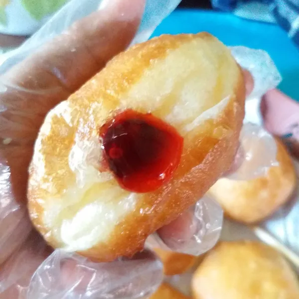 Ambil bombolini, lubangi dengan sumpit, lalu masukkan selai. Gulingkan kedalan tepung gula. Tata bombolini dan sajikan.