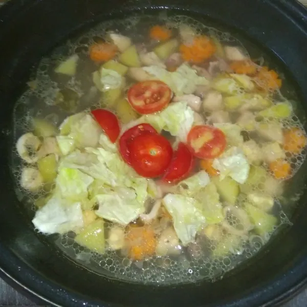 Setelah matang tambahkan daun kol dan tomat, masak hingga setengah layu. koreksi rasa, matikan api, setelah dingin,tuang sayur bening dalam mangkuk saji.