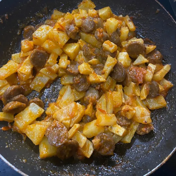 Masukkan kentang dan sosis, aduk merata dan tunggu hingga meresap.