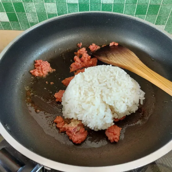 Tambahkan nasi putih, lada dan pala bubuk. Aduk rata.