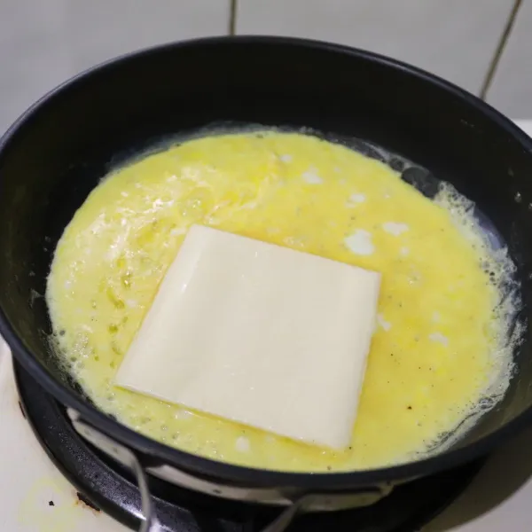 panaskan wajan, beri margarin, masak telur perlahan beri keju gulung dan tuang telur sedikit demi sedikit beri Nori dan gulung lagi, tiriskan.