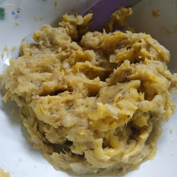 Kupas pisang yang sudah dikukus kemudian haluskan.