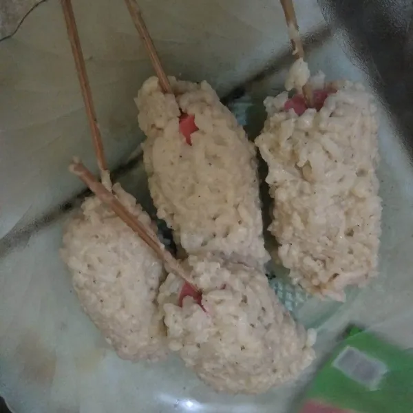 Kepalkan nasi pada sosis.