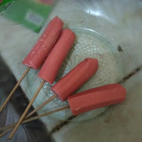 Potong sosis menjadi 2 bagian lalu tusukan pada tusuk sate.