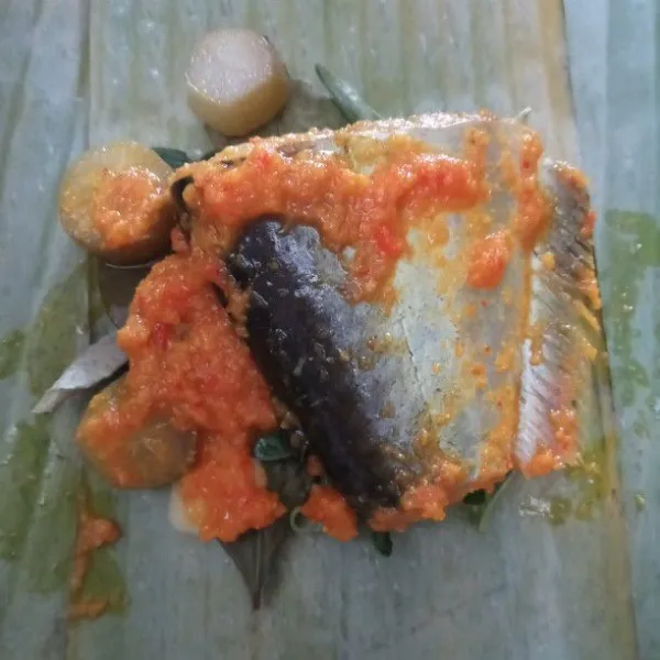 Taruh ikan patin di atas daun yang sudah diberi bahan pepesan. Bungkus dengan rapih sesuai selera.