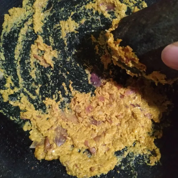 Ulek bumbu yaitu bawang merah, bawang putih, kunyit bubuk, ketumbar bubuk, merica bubuk, dan kemiri hingga halus.