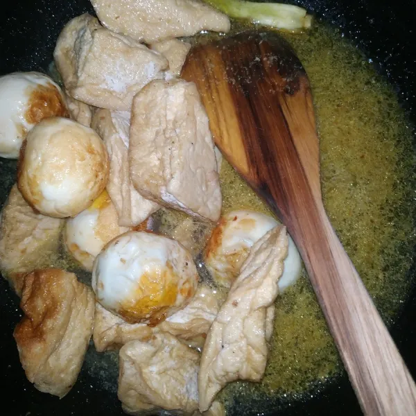 Masukan telur dan tahu yang sudah digoreng sebelumnya. Masak hingga air mendidih dan air menyusut.