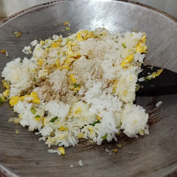 Masukkan nasi putih, bumbui merica bubuk dan kecap asin. Aduk sampai tercampur rata.