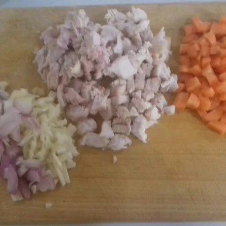 Cincang halus bawang putih dan bawang merah, suwir-suwir ayam rebus dan wortel dipotong dadu kecil.