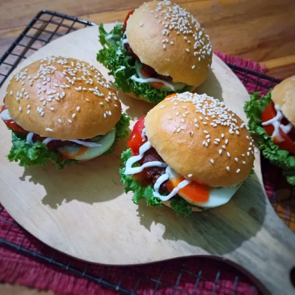 Penyelesaian : Belah roti burger, beri 1 lembar daun selada, letakkan patty burger, beri irisan tomat dan timun. Beri secukupnya mayonaise dan saus sambal botolan. Tutup dengan roti. Siap dinikmati.