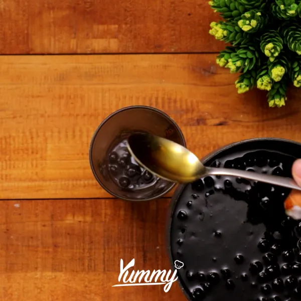 Tuangkan sirup caramel dalam gelas, tuangkan boba yang telah dimasak.
