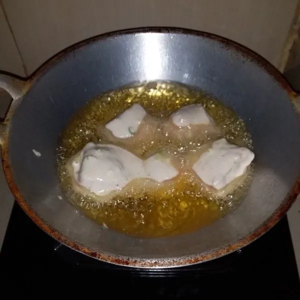 Panaskan minyak goreng. Celupkan tahu ke dalam adonan tepung langsung masukkan ke dalam minyak panas. Goreng hingga berwarna keemasan. Angkat dan tiriskan.