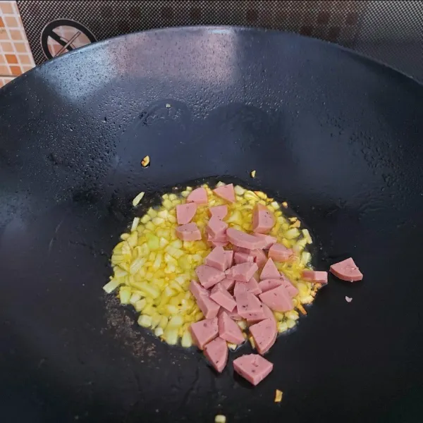 Panaskan margarin, tumis bawang bombay dan bawang putih sampai wangi. Masukkan sosis, aduk sebentar hingga rata.