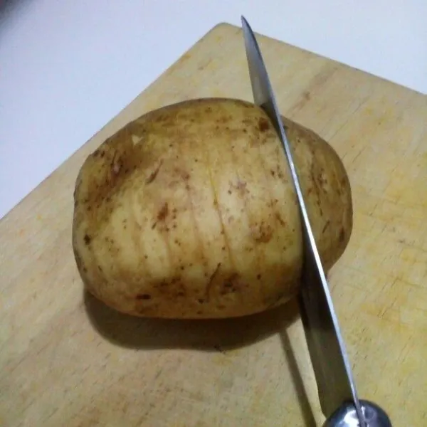 Cuci bersih kentang, kulit tidak perlu dikupas. Kerat dari ujung ke ujung agak tipis tapi jangan sampai putus.