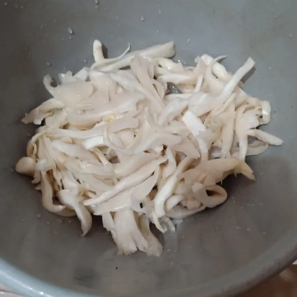 Suir jamur tiram lalu cuci hingga bersih.