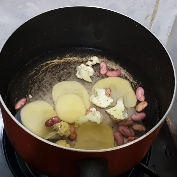 Rebus kentang, kacang merah dan kembang kol sampai empuk.