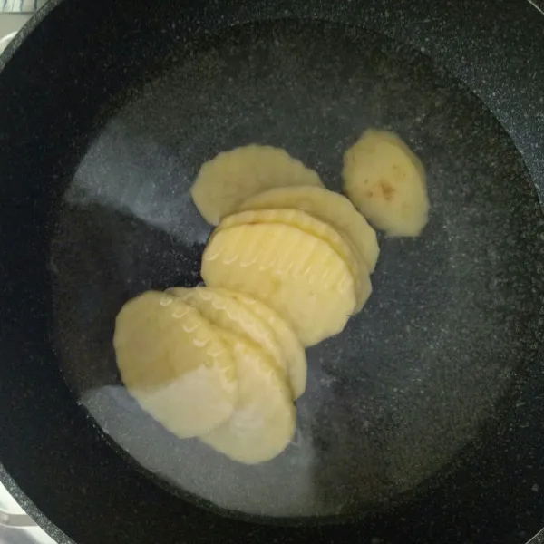 Potong kentang tipis lalu rebus hingga matang.