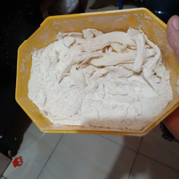 Masukkan jamur ke dalam tepung lalu lumuri permukaan jamur (gunakan wadah bertutup lalu kocok-kocok).