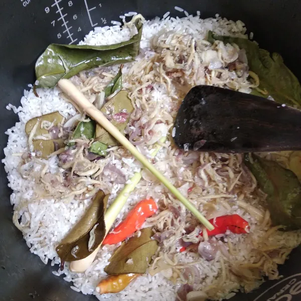 Masukkan beras ke dalam magicom. Tuang tumisan bawang bersama minyaknya. Masukkan bahan lain kemudian tuang air secukupnya seperti menanak nasi, tekan tombol. Cook dan biarkan sampai matang.