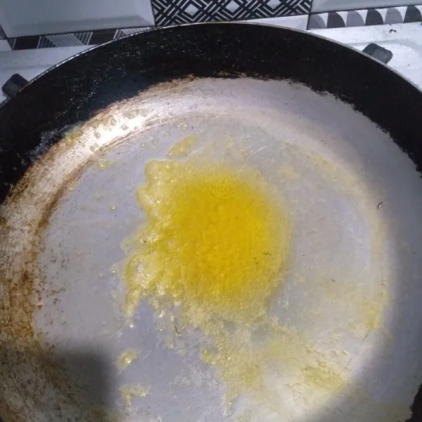 Oles margarin pada teflon.