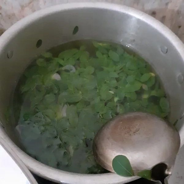 Masukkan daun kelor dan daun kemangi. Beri gula, garam, dan micin. Masak selama 1 menit. Koreksi rasa.