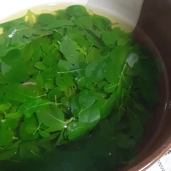 Tuang sayur bening kelor dalam mangkuk. Siap disajikan.