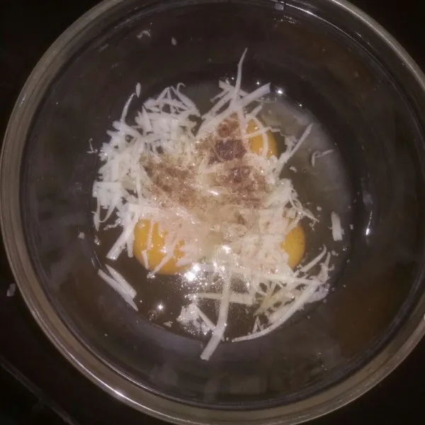 Campurkan 3 butir telur, keju parut, lada bubuk, dan juga garam dalam satu wadah.