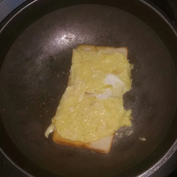 Balik, lipat telur ke atas roti.