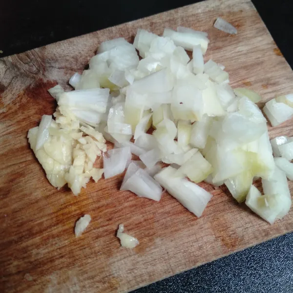 Cincang bawang putih dan bawang bombay.