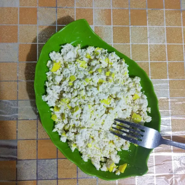 Haluskan tahu menggunakan garpu.