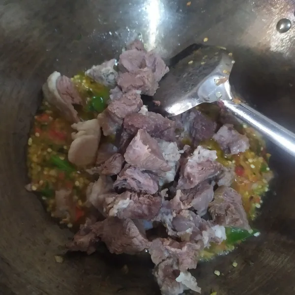 Masukkan daging, tambahkan garam, gula dan kaldu bubuk, sesuaikan rasanya.