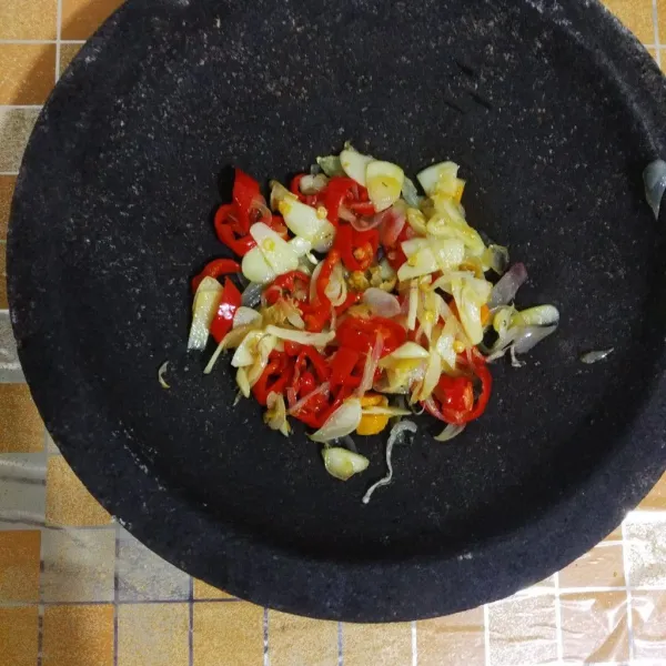 Iris bawang merah, bawang putih, dan cabai merah. Tumis lalu haluskan.