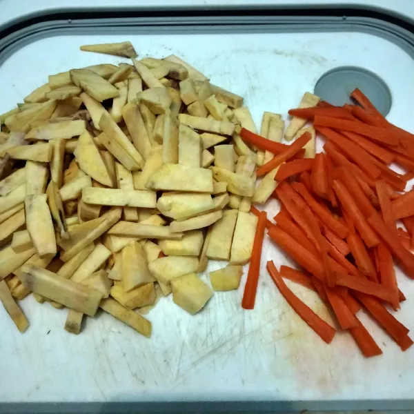 Kupas dan bersihkan ubi dan wortel, lalu potong memanjang