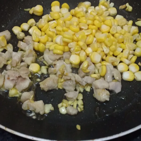 Masukkan ayam, aduk sampai berubah warna, tambahkan jagung serut, aduk lalu tambahkan air.